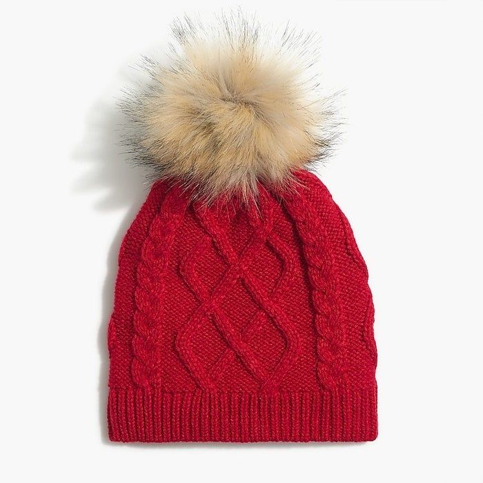 A vibrant red hat adorned with a light brown pom-pom
