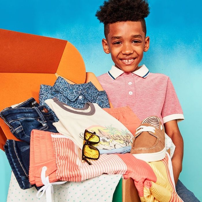 Model showcasing a KidPik box filled with clothing