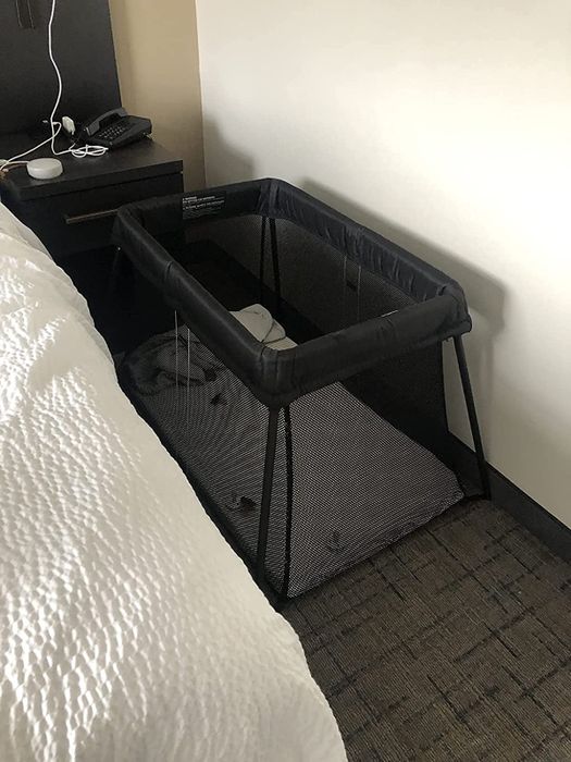 image of the travel crib placed between a hotel bed and the wall