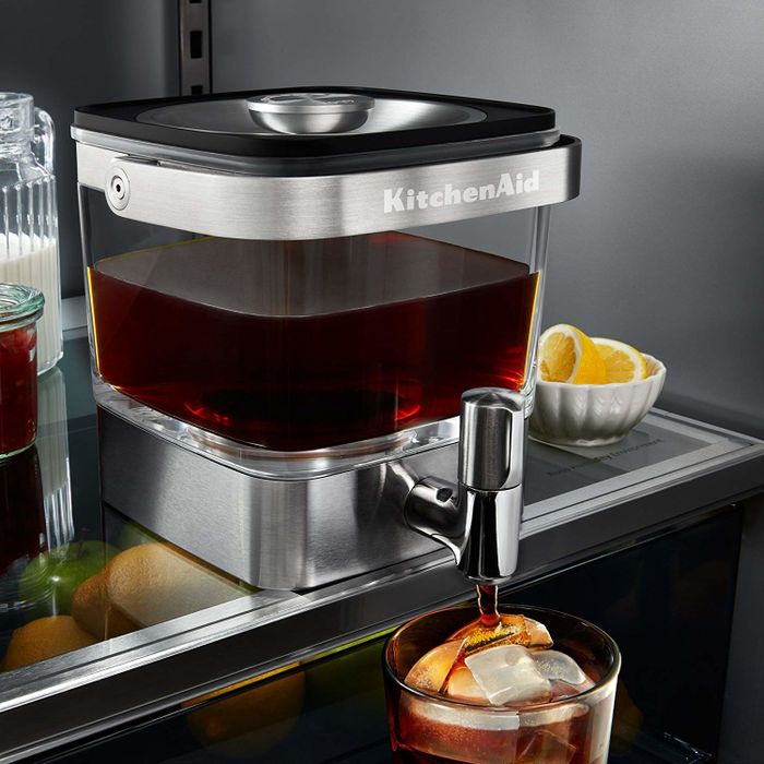 A sleek stainless steel cold brew maker with a spout, sitting comfortably in the fridge.