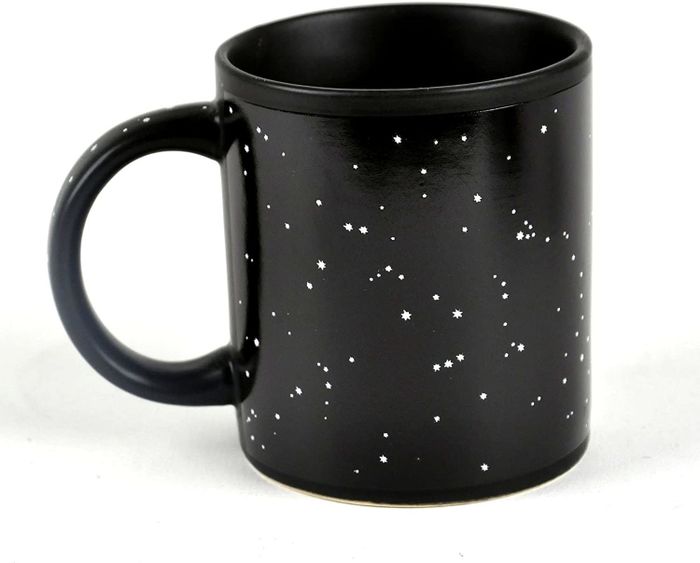 The mug in its cold state, showing a black design with scattered stars.