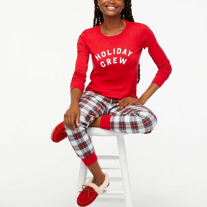 A model dressed in a red top paired with red plaid pants and matching red shoes