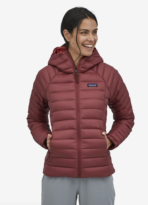 Model wearing a dark red puffer jacket with their hands in their pockets
