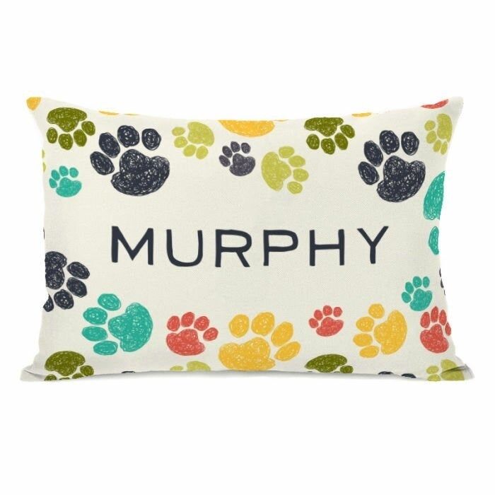 The pillow adorned with paw prints in green, teal, navy, yellow, and coral, featuring the name 'Murphy'.