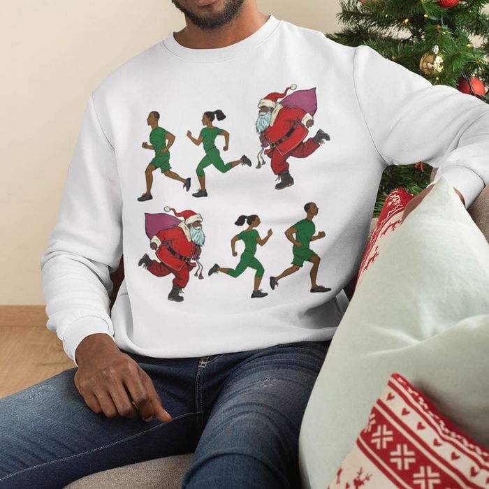 A person sporting a sweatshirt with an animated runner in green workout gear, with a cheerful Santa Claus jogging behind them, carrying a large bag full of presents.
