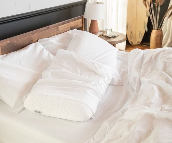 A cozy shot of the pillows arranged on an unmade bed, giving a relaxed vibe.