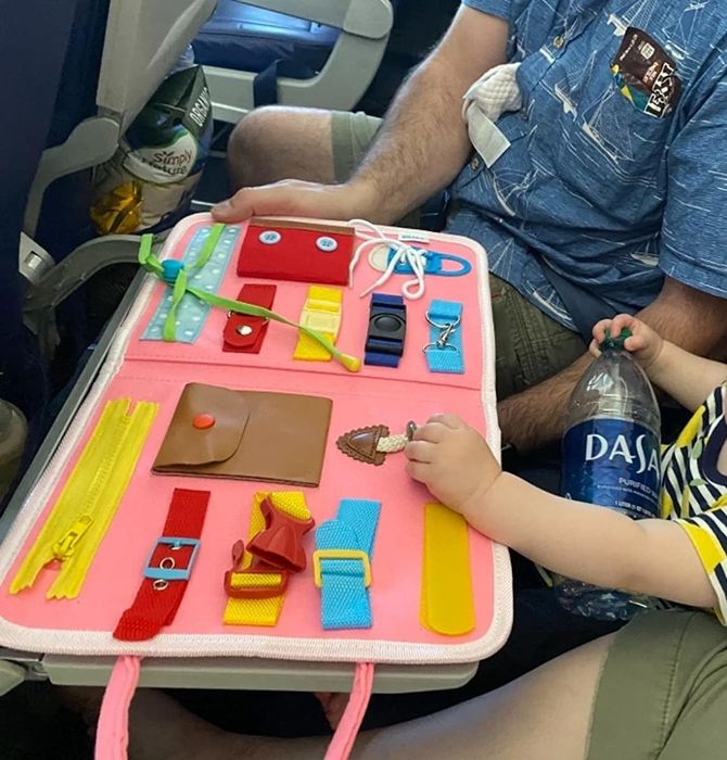 Image of a toddler enjoying the busy board on a flight
