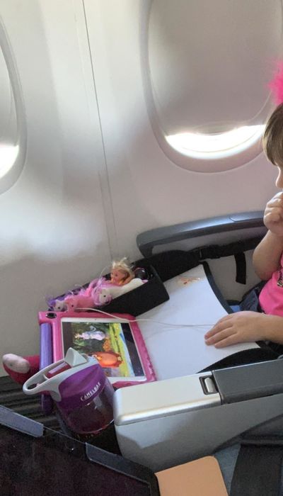 Reviewer’s photo of a child enjoying their tablet on the tray table aboard the plane