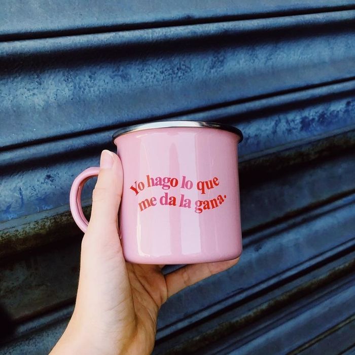 A pink enamel mug that reads 