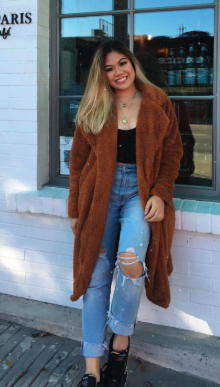 A reviewer wearing the coat in brown