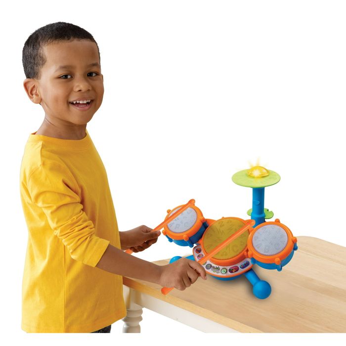 A boy enjoying playing the drums.