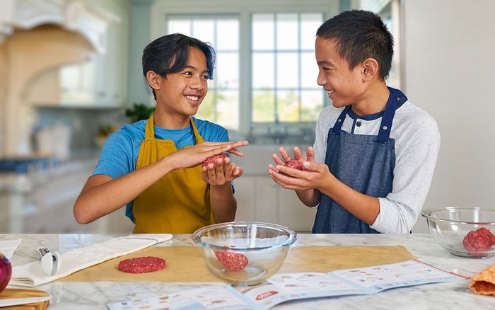 two children preparing hamburger patties