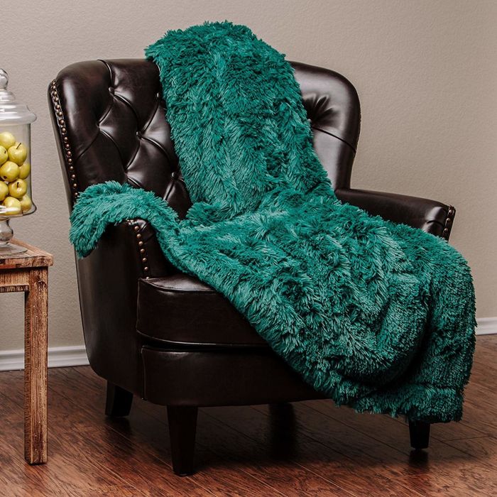 The cozy green blanket draped over a chair.