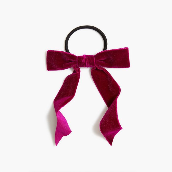 A ponytail holder featuring a luxurious red velvet bow