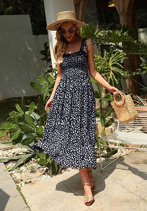 The model is wearing the navy blue maxi dress with white dots.