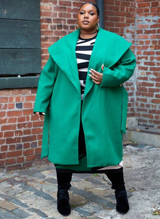 A plus-size model in a bold, bright green collared coat