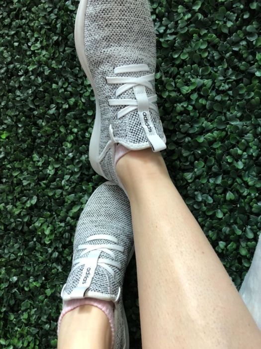 A reviewer rocking the grey Adidas Cloudfoam sneakers.