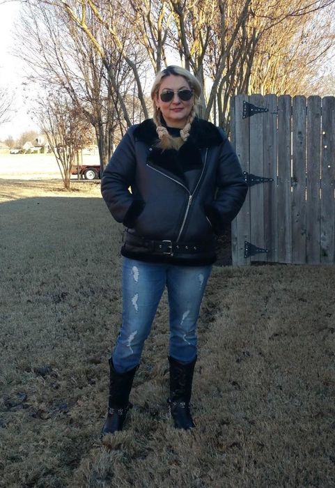 A reviewer wearing a black faux shearling coat