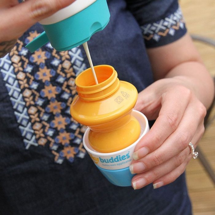 A parent filling the sunscreen into the applicator