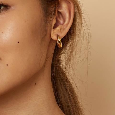Model showcasing the gold chunky hoops