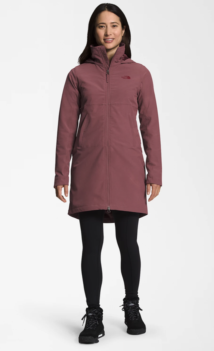 Model showcasing a mid-thigh length parka in a striking pink/red hue