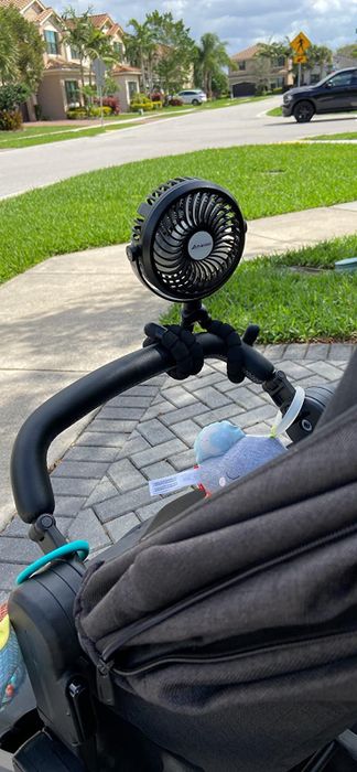 A reviewer’s photo showing the black fan attached to a stroller