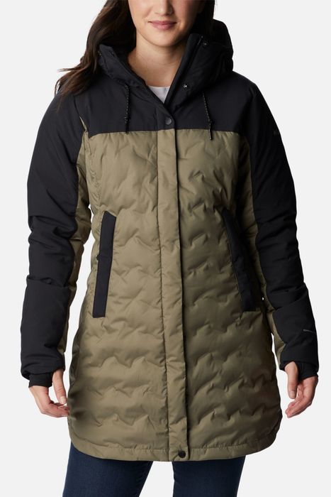 Model in a quilted down jacket with black sleeves and chest, paired with a green body.