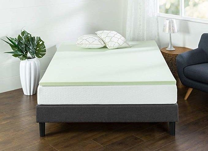 The light green memory foam topper placed on a mattress.