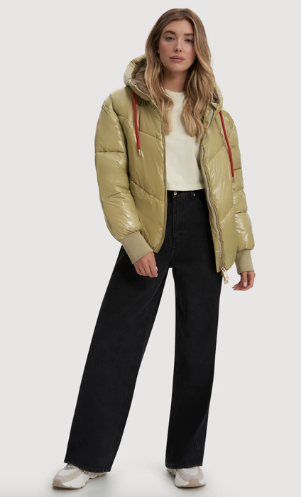 Model showcasing a glossy, short puffer coat in light green with red drawstrings