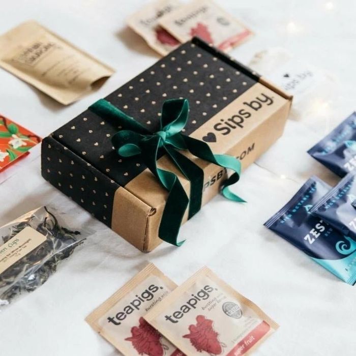 A gift box surrounded by various tea packets.