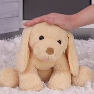 A hand gently petting the plush yellow lab, bringing it to life.