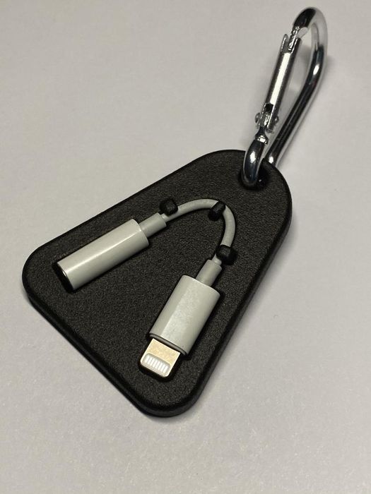 The triangular case, equipped with latches to secure the dongle, attached to a keychain