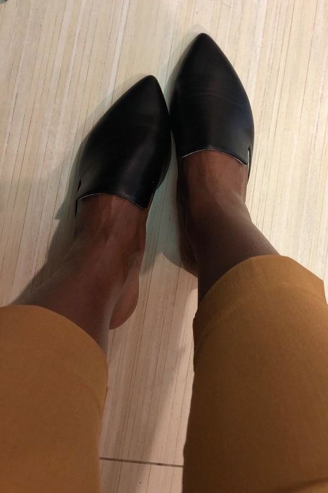 A reviewer rocking the mules in a sleek black color.
