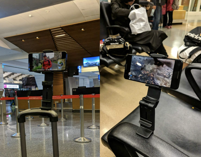 Phone mounted on a carry-on luggage handle and the armrest of a chair