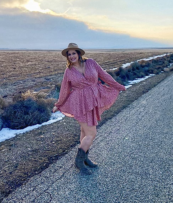 A reviewer is seen wearing the wrap dress in a lovely pink shade.