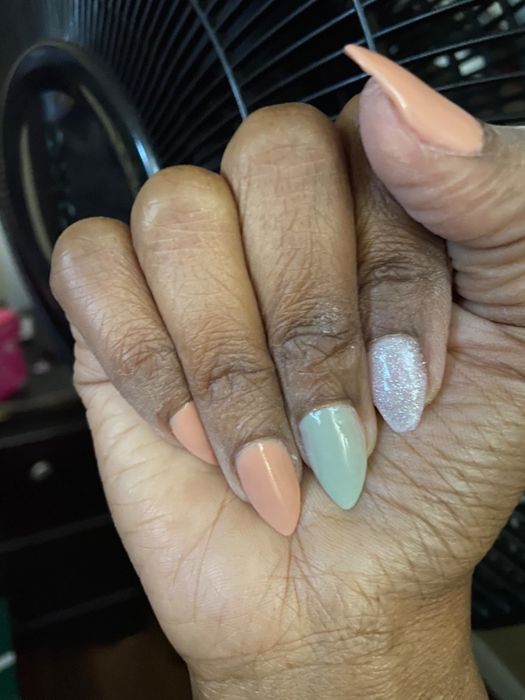 A reviewer with pointed nails painted in different pastel shades
