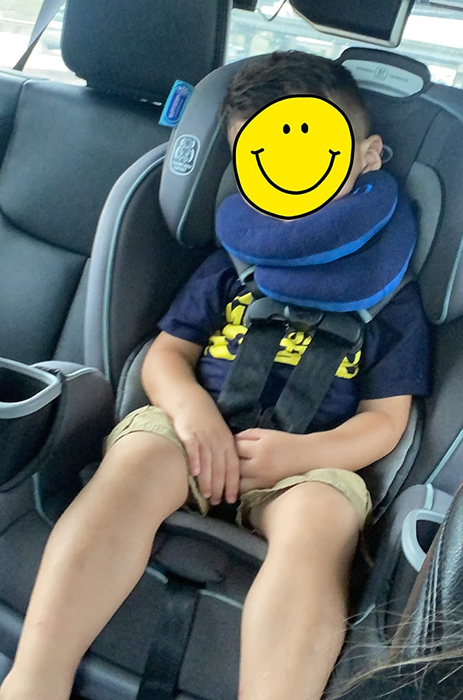 Image of a child sleeping in the car with the neck pillow on