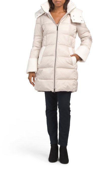 Model showing off a long white puffer coat with fleece-lined pockets and sleeves.