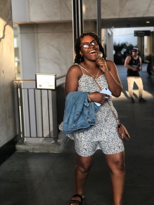 The reviewer is wearing the dress in a delicate pale blue floral print.