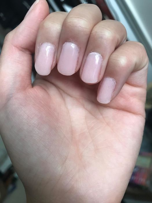 A reviewer showing off their pale pink nails