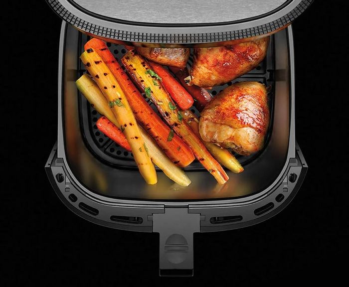 An 8-quart air fryer shown with cooked chicken and vegetables inside. Perfect for preparing family-sized meals.
