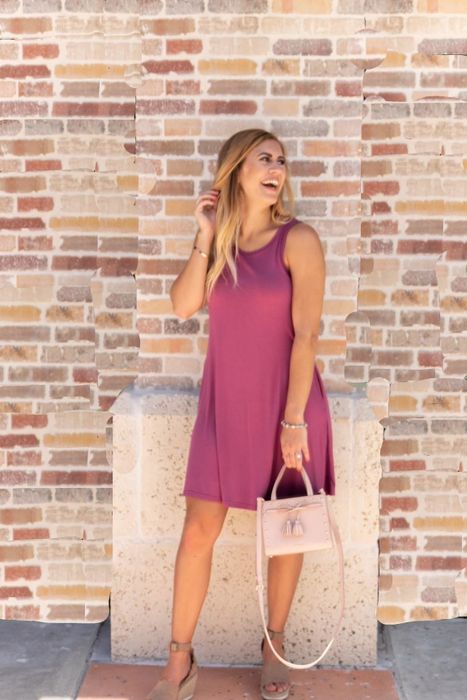 A reviewer is seen wearing the dress in pink.