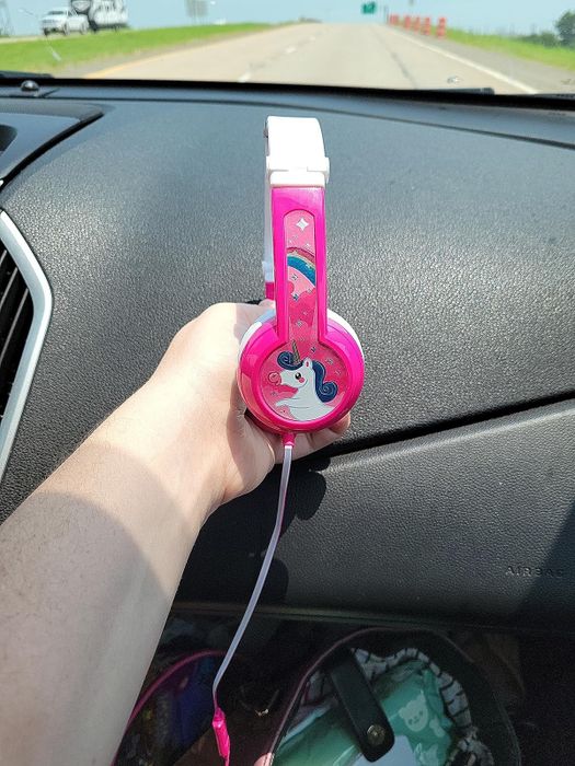 A reviewer holding their child’s headphones