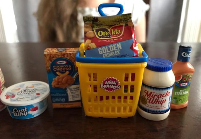 Reviewer's collection of mini toys, including Cool Whip, Miracle Whip, salad dressing, French fries, and Kraft mac and cheese.