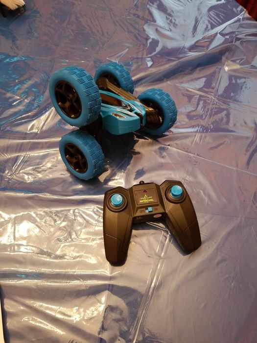 A reviewer's blue remote-control car beside its black controller