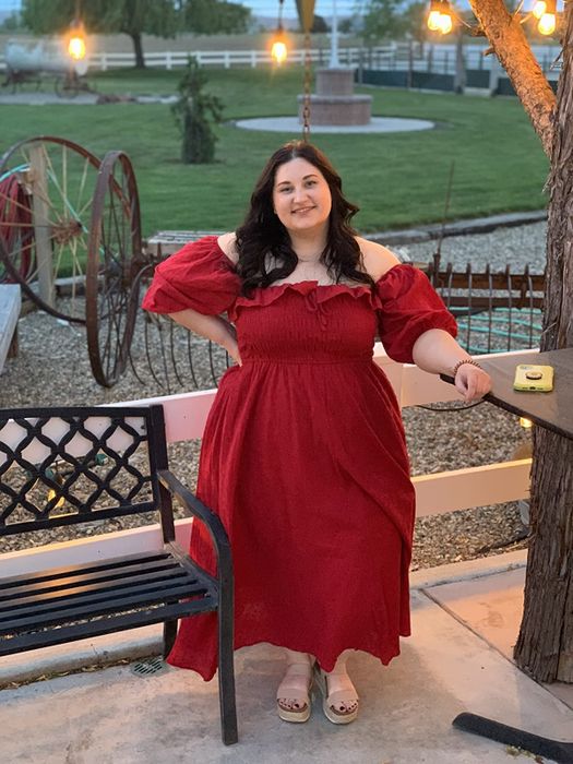 Another reviewer in red, with the sleeves elegantly draped off their shoulders