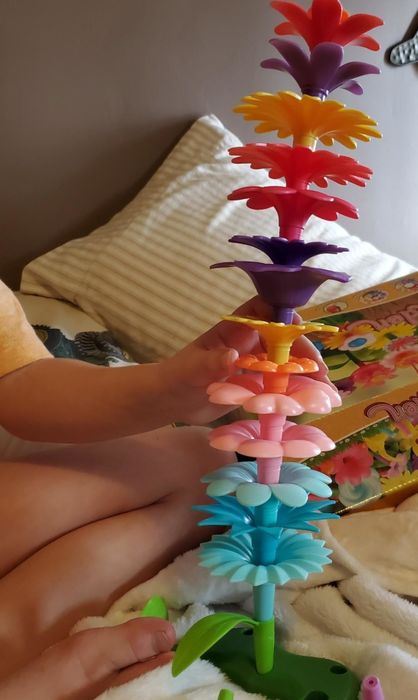 A reviewer's photo showing plastic flower toys stacked into a tower