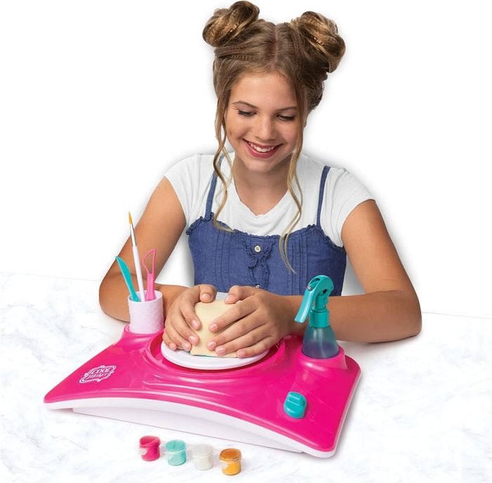 A child using the kit to craft a pottery piece with clay
