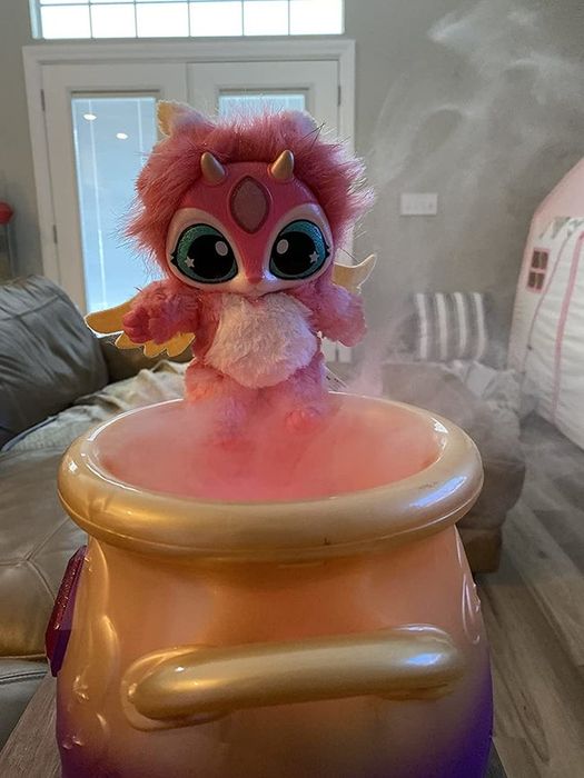 A soft, furry toy sitting on a smoking plastic cauldron
