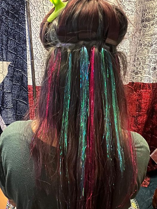 A reviewer’s child with their hair parted to display the tinsel